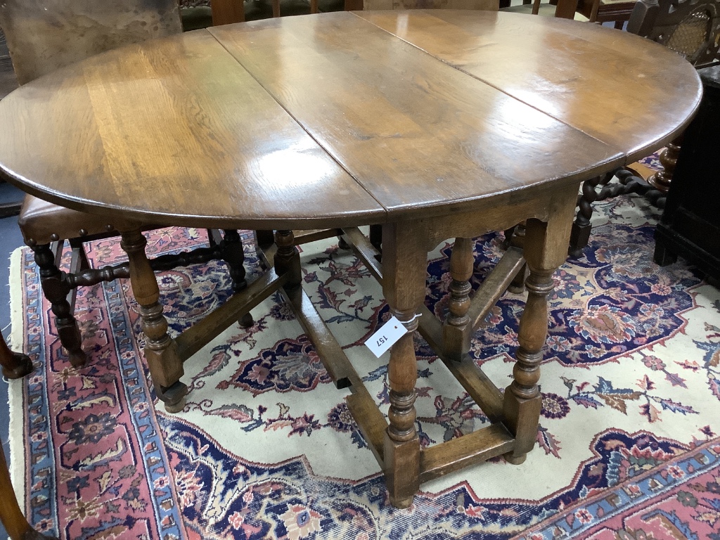 An 18th century style oval oak gateleg dining table, length 150cm extended, width 122cm, height 75cm